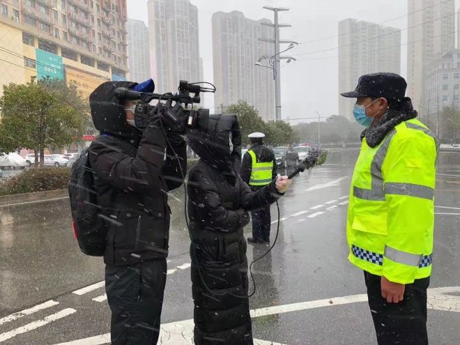 孝感市融媒體中心楊亞玲（風(fēng)雪中，采訪疫情期間重返一線的退休警察）_副本.jpg.jpg